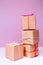 Craft cardboard gift boxes on the solid pink background. Holiday