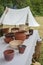 Craft ceramist shows clay jars and pots at potter workplace on festival workshop, artisanal ware