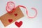 Craft envelop with Red fabric hearts and red ribbon on white background. Valentine`s day greeting card.