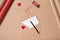 Craft envelope with red heart, blank paper and pen on beige table. Wrapping. Love concept. Saint Valentine`s Day concept