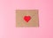Craft envelope sealed with a red heart on a pink background. Valentines Day, valentine. Close-up