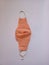 craft masks from fabric base materials.  This masjer is orange with both white straps.  This mask photo is on a white background