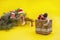 Craft natrual winter gift rustic box on yellow background with fir branches and handmade knitted toys in blur