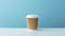 craft paper coffee cup on white table, blue wall background with copy space