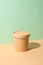 Craft paper soup cup with shadow on green and brown natural color paper. Empty container. Ecological individual package. Zero