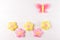 Craft pink and yellow butterfly and flowers, copyspace on white wooden background. Hand made felt toys. Abstract sky.