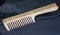 Craft wooden comb on a dark blue background.