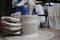 A craftsman with 13 years of experience unscrews a cylinder on a potter`s wheel - the fundamental form of any ceramic product and