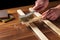 The craftsman cleans the wood plank with an abrasive tool. Builder hands close up. Renovation or construction idea