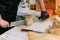 Craftsman cuts handmade cheese in a shop