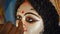 A craftsman giving finishing touches to the eyes of Goddess Durga\'s sculpture