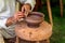 Craftsman hand making pottery from clay on potters wheel