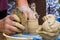 Craftsman hands form a clay bowl on a traditional pottery wheel, ethnography lesson in producing of traditional eco friendly goods