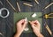 Craftsman hands working on human sculpture, sculpturing from polymer clay against working table with tools. Flat lay, top view