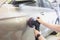 Craftsman polishes car door with eccentric sander in car service closeup