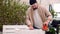 Craftsman polishes a wooden pallet furniture with orbital sander machine, furniture restoration. Seasonal house chores, woodworkin