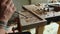 A craftsman processes a walnut board with a chisel. artisan makes a tea tray. woodcarver art. vagatabon