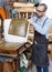 Craftsman reupholstering chair in workshop