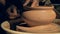 A craftsman shaping a vase with a fork, close up.