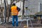A craftsman is standing at a construction site near surveying equipment.