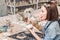 Craftsman working with earthenware product for sale in her shop. Pottery business concept for an artist concept