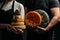 Craftsmanship hands have a typical Italian cheese. French tomme cheese in the hands of a cheesemaker on dark background. Different