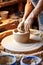 Craftsmanship in Motion: Skilled Potter Creating a Vase on Spinning Wheel