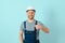 Craftsmen or electrician man over isolated blue background giving a thumbs up gesture