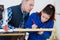 Craftsmen supervising female apprentice working carpentry shop