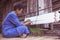 Craftsperson working. Old woman process homespun cotton fabric weaving in community. Senior women create fabric pattern form