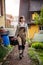 a craftswoman carrying a toolbox and walking through a garden