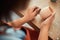 Craftswoman hands sanding clay pot in pottery workshop