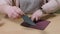 Craftswoman`s hands gluing parts of leather purse