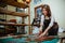 craftswoman using cutter knife and ruler to cut leather