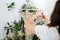 Craftswoman working on unfinished section of a macrame piece at home greenhouse