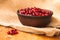 Cranberries in a clay bowl, stands on the table.