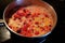 Cranberries simmering in pot on stove