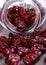 Cranberries spilling out of glass jar on concrete