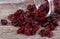 Cranberries spilling out of glass jar on wooden table