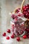 Cranberries with sugar in glass jar and basket with berries