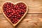 Cranberries on wooden tray on brown wooden background.