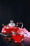 Cranberry herbal hot tea drink in glass teapot with cinnamon and