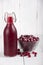 Cranberry juice in a bottle and a cranberries in a glass bowl