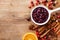 Cranberry sauce in ceramic saucepan with ingredients for cooking on kitchen wooden table top view