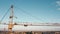 Crane against blue sky and city horizon, industrial zone