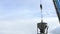 Crane bucket dumps gravel into a silo at a concrete plant