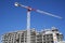 Crane and building construction activity with blue sky background