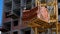 Crane and building construction site against blue sky. heavy load hanging on the hook of a crane on the construction of