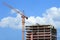 Crane and building under construction against blue sky.