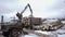 Crane claw loader unloads wood logs from heavy truck at sawmill facility